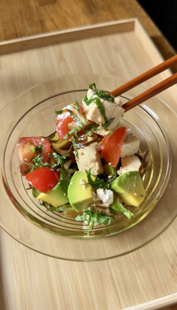 Japanese tofu and avocado salad with cherry tomatoes, shiso, and shio kombu in a glass bowl